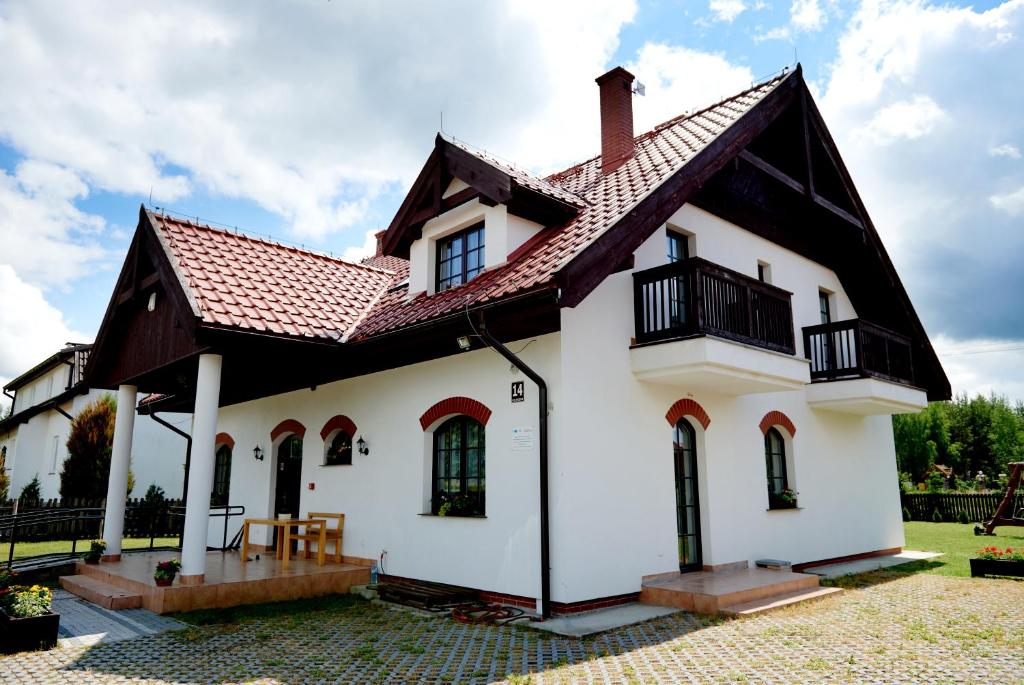 a white house with a brown roof at Willa Cicho Sza in Węgorzewo