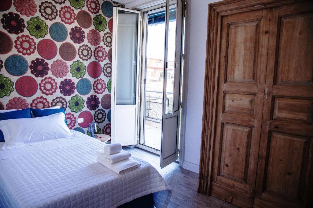 1 dormitorio con 1 cama y puerta corredera de cristal en Catania Charming House, en Catania
