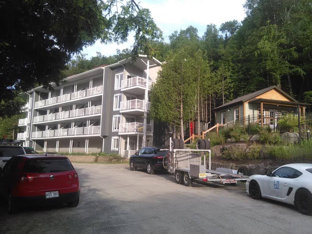 een groot appartementencomplex met voertuigen die ervoor geparkeerd staan bij Bernache in Mont-Tremblant