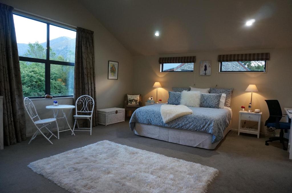 a bedroom with a bed and a table and chairs at Haven Suite Luxury 5 Star in Queenstown