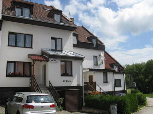 a white house with a car parked in front of it at Apartmany u Lipno in Frymburk