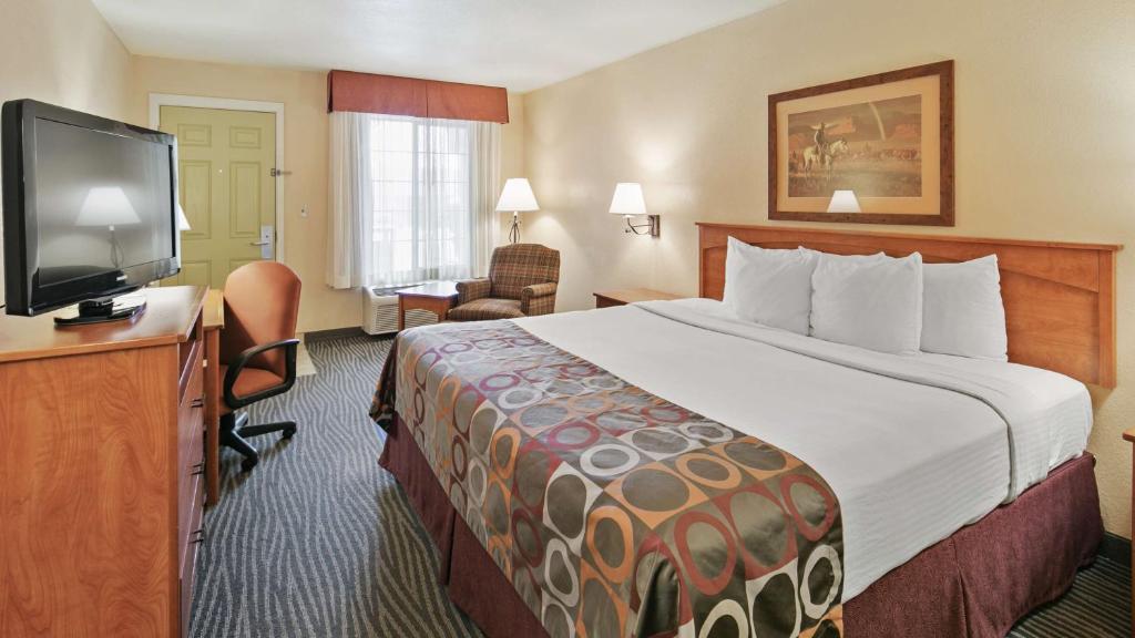 um quarto de hotel com uma cama e uma televisão de ecrã plano em Best Western Desert Inn em Safford