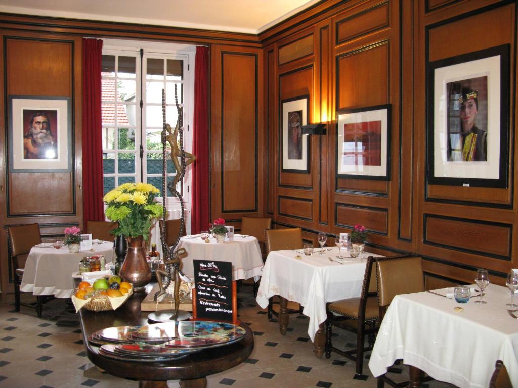 a restaurant with two tables with white tablecloths at Hôtellerie Du Bas-Bréau in Barbizon