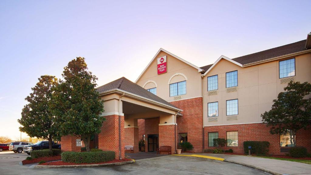 a hotel with a sign on the front of a building at Best Western Plus Executive Hotel & Suites in Sulphur