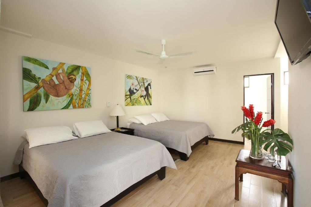 a hotel room with two beds and a tv at Casa María Aeropuerto B&B in Alajuela City