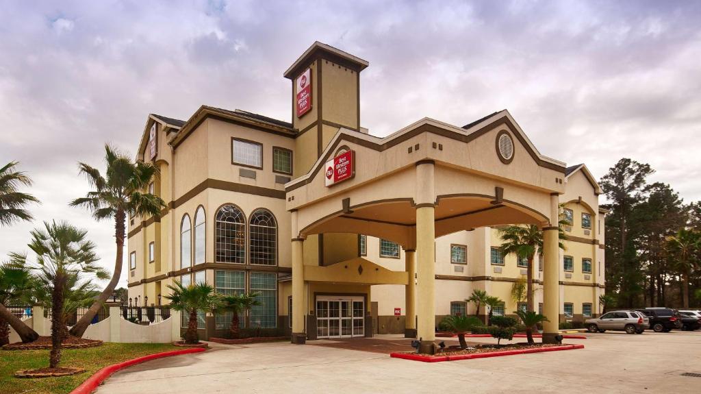 un grande edificio con un orologio sopra di Best Western Plus New Caney Inn & Suites a New Caney