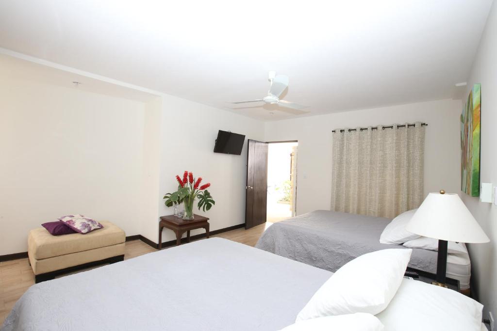 
a hotel room with a white bed and white furniture at Casa María Aeropuerto B&B in Alajuela
