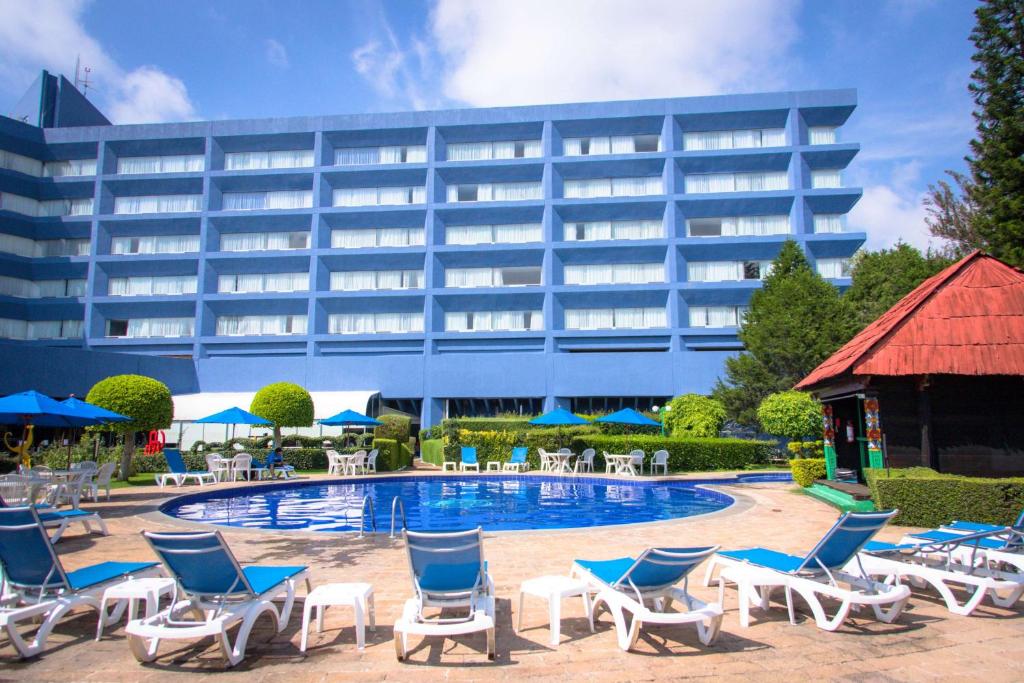 a hotel with chairs and a pool and a building at Best Western PLUS Gran Hotel Morelia in Morelia
