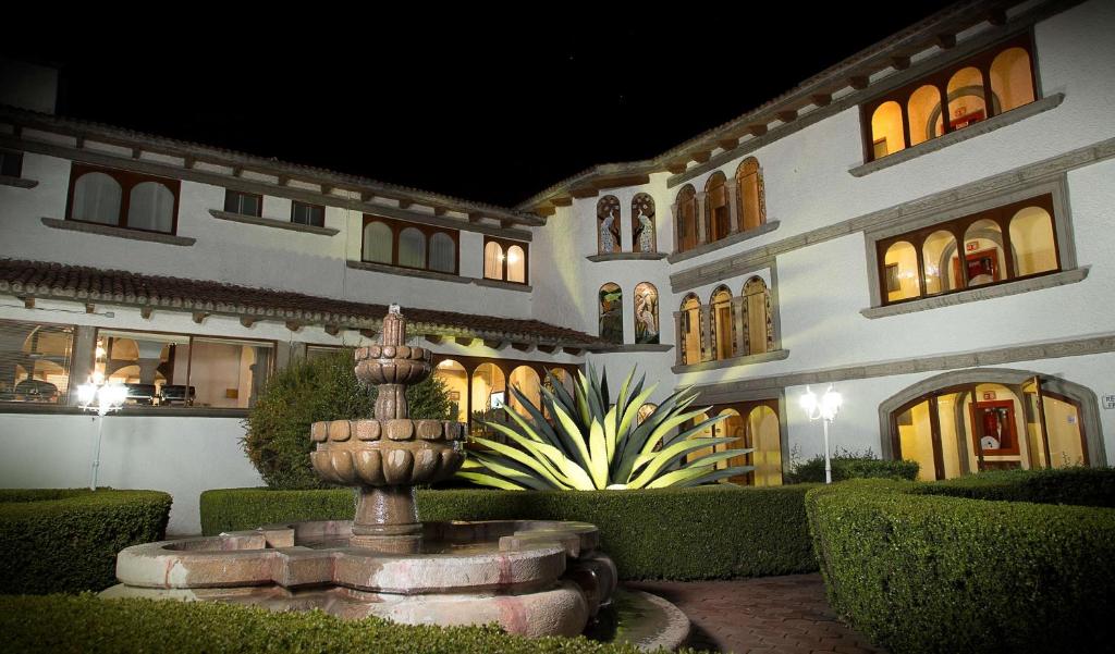 un grand bâtiment avec une fontaine devant lui dans l'établissement Hotel Del Angel, à Apizaco