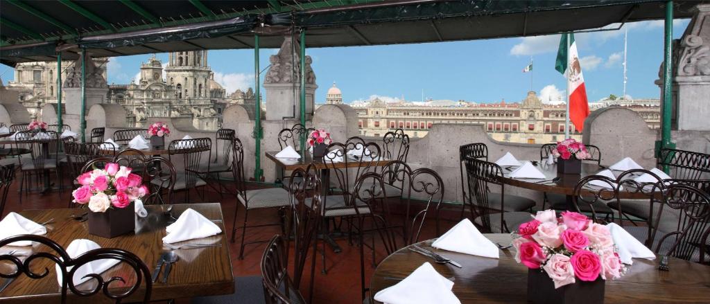 ein Restaurant mit Tischen und Stühlen und Stadtblick in der Unterkunft Best Western Majestic in Mexiko-Stadt