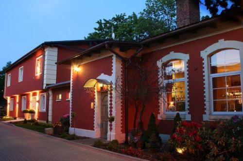 una casa roja con luces en el costado. en Villa Intryga, en Słupsk