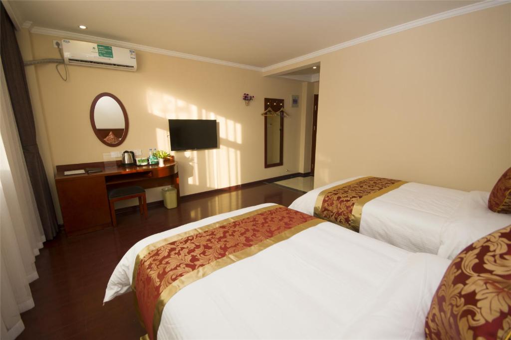 a hotel room with two beds and a desk at GreenTree Inn Zhuhai Mingzhu Station Express Hotel in Zhuhai