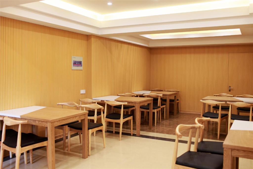 a row of tables and chairs in a room at GreenTree Inn Henan Kaifeng Jinming District Jinming Square Little Song City Business Hotel in Kaifeng