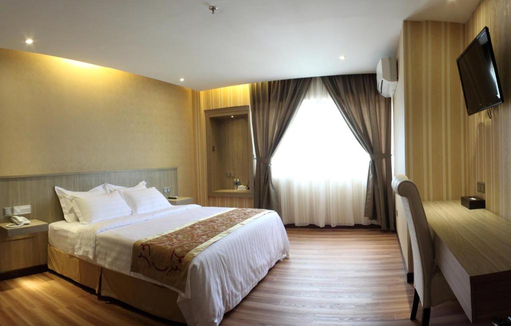 Postel nebo postele na pokoji v ubytování Mandarin Hotel Kota Kinabalu