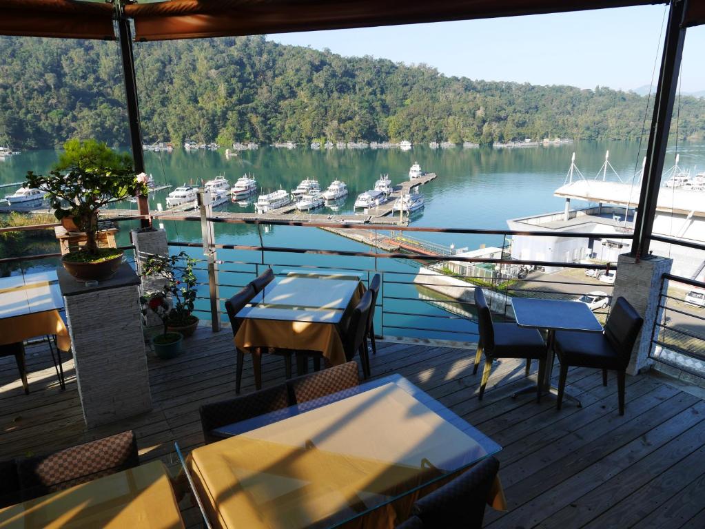 魚池鄉的住宿－澄園旅店，水中带桌椅和船只的甲板