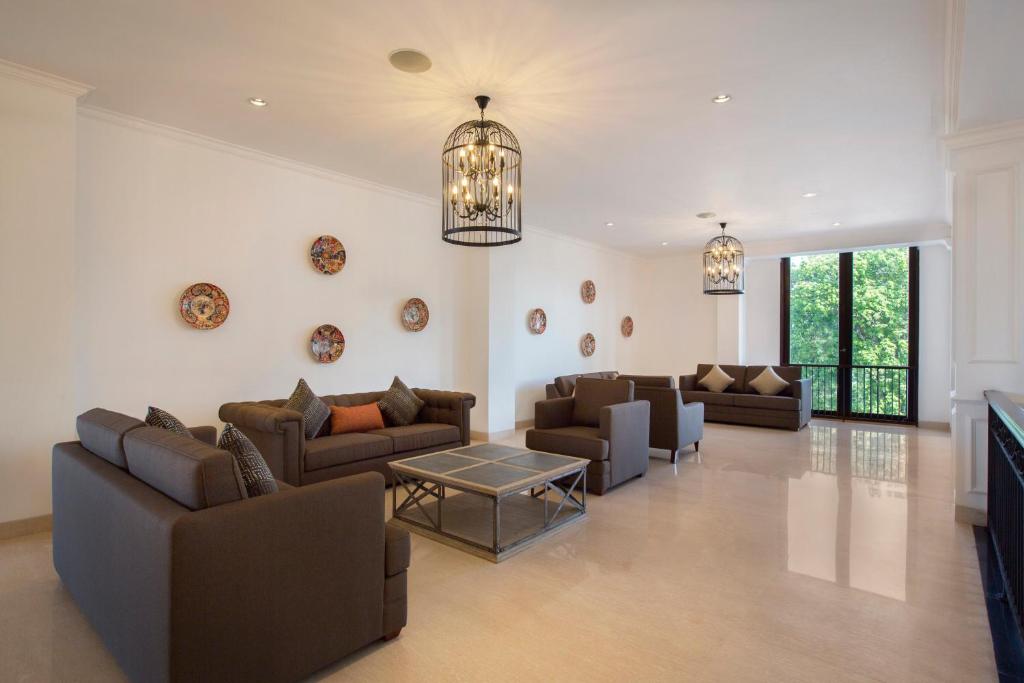 a living room with couches and a chandelier at Grand Palace Hotel Sanur - Bali in Sanur