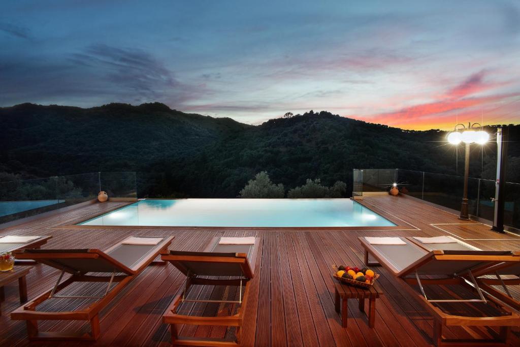 - une piscine sur une terrasse avec des chaises et une table dans l'établissement Villa Drakona, à Keramia