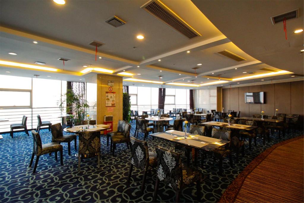 ein Restaurant mit Tischen und Stühlen in einem Zimmer in der Unterkunft GreenTree Eastern GuangDong FoShan ShunDe District Huicong City Hotel in Shunde