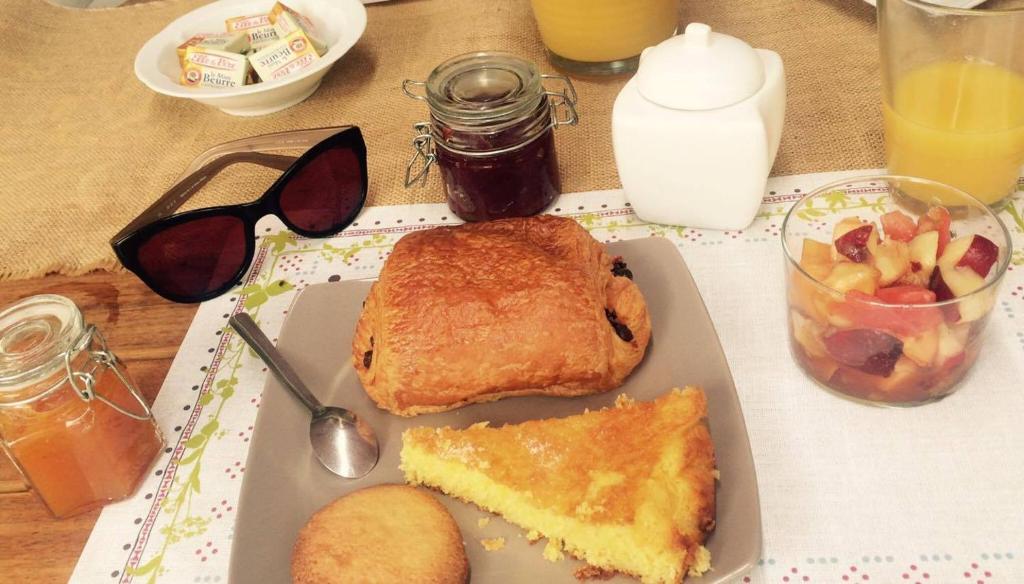 a table with a plate of food with a sandwich and fruit at L'Amirauté sur Baïse in Saint-Jean-Poutge