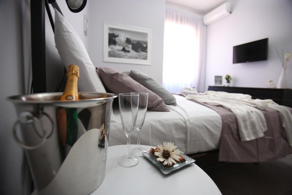 Schlafzimmer mit einem Bett und einem Tisch mit einem Glas Wein in der Unterkunft AmalfiCoastApartments in Salerno