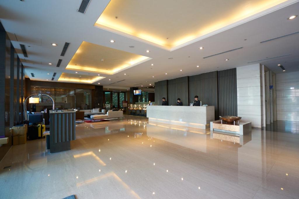 a lobby of a hotel with people standing at a counter at Taipung Suites in Anping