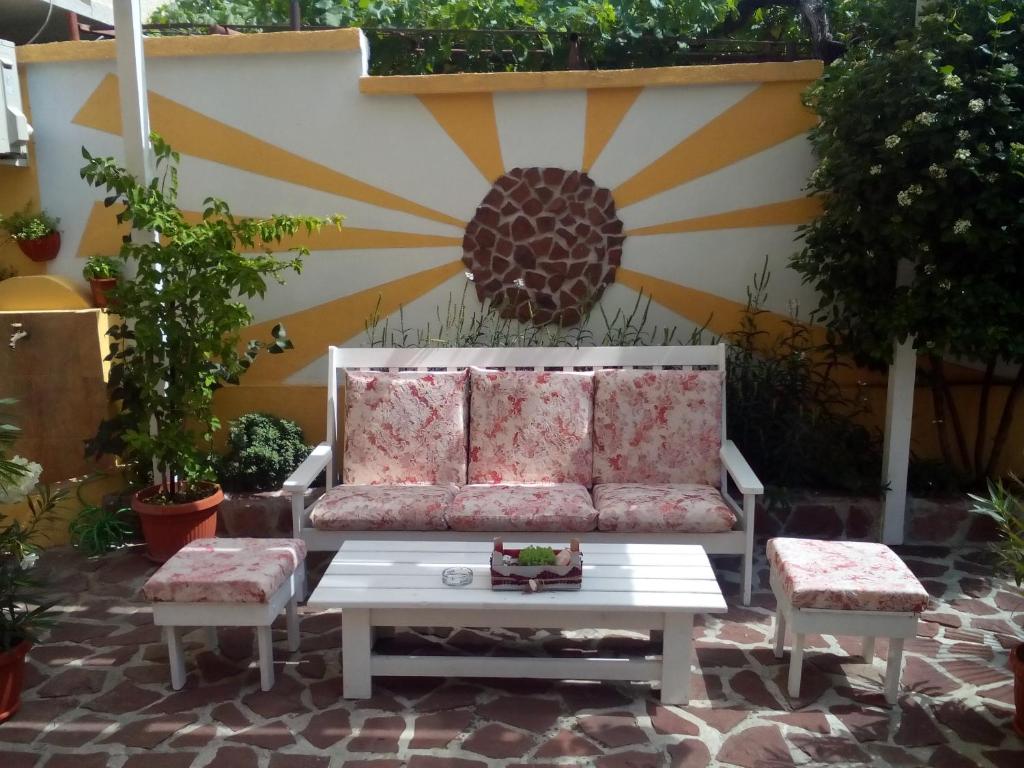 un sofá en un patio con 2 sillas y una mesa en Guest House Аnestievi, en Ahtopol