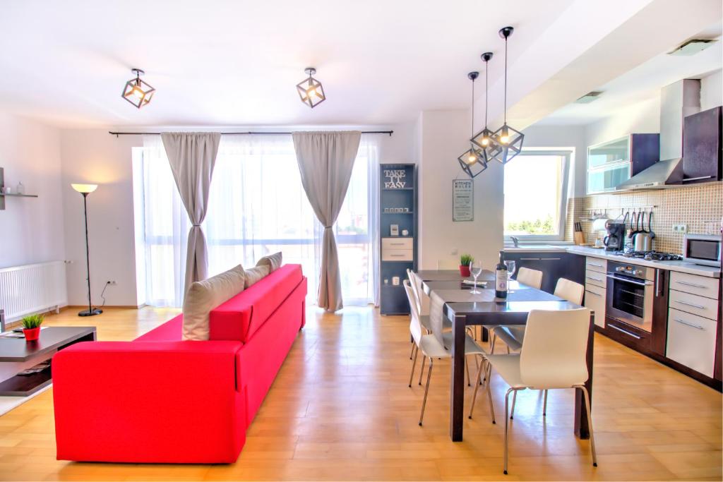 a living room with a red couch and a table at Europe Residence Central Apartment in Braşov