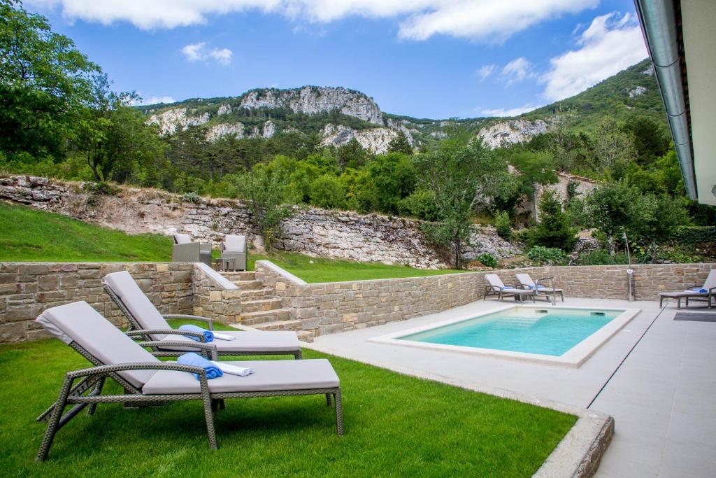 een patio met stoelen en een zwembad bij Villa Orljak in Lanišće