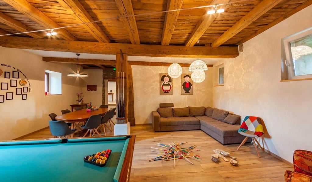 a living room with a couch and a pool table at Le gîte des Histoires in Kientzheim