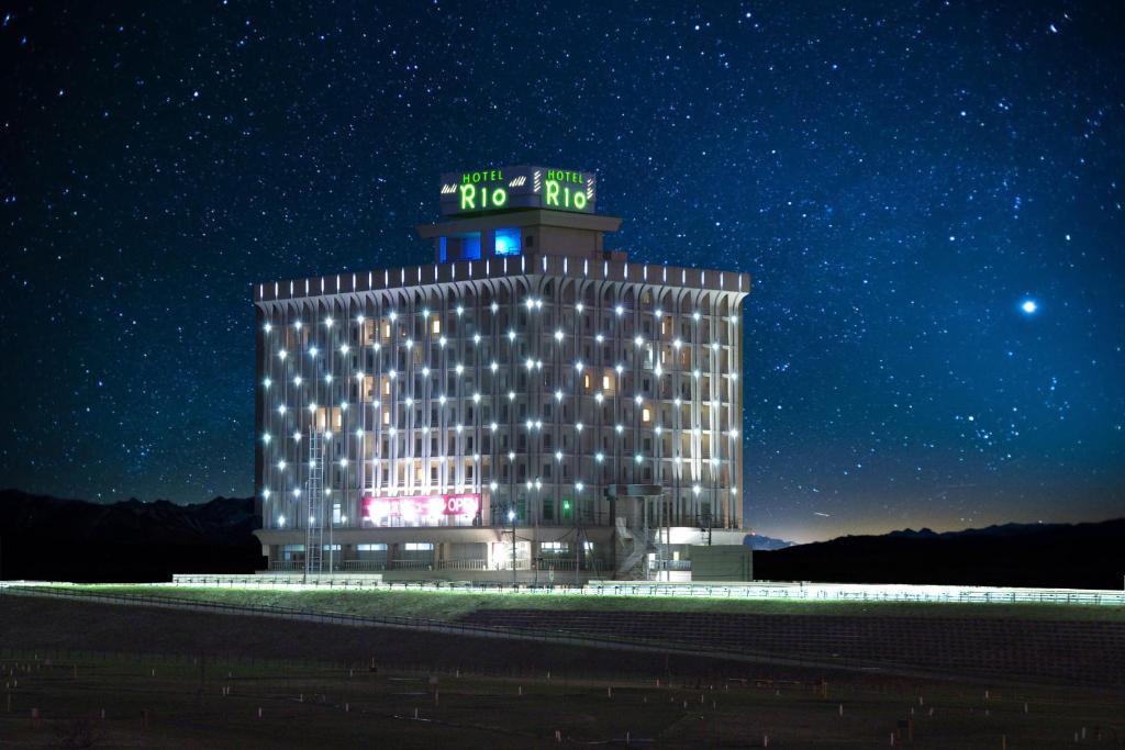 un edificio de hotel con un cartel encima por la noche en Hotel Rio (Adult Only), en Sapporo