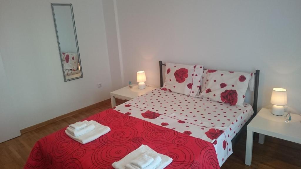 ein Schlafzimmer mit einem roten Bett mit zwei Tischen und zwei Kerzen in der Unterkunft Bozena Apartment in Athen