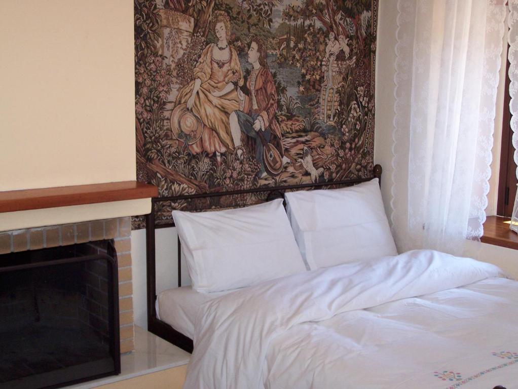 a bed in a room with a tapestry on the wall at Diavatiko in Stemnitsa