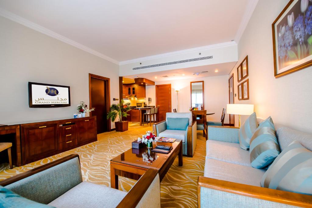 a living room with couches and a table at Grand Mercure Majlis Residences in Abu Dhabi