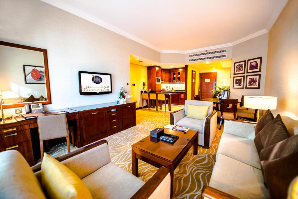 a living room with a couch and a table at Grand Mercure Majlis Residences in Abu Dhabi