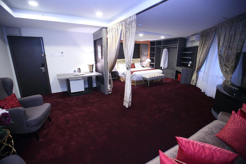 een hotelkamer met een bed en een bank bij Al Khatiri Hotel in Kubang Kerian