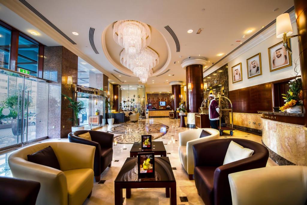 a lobby of a hotel with chairs and a table at Grand Mercure Majlis Residences in Abu Dhabi