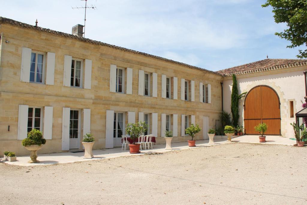 un grand bâtiment avec des plantes en pot devant lui dans l'établissement La Demeure de Bayard, à Montagne