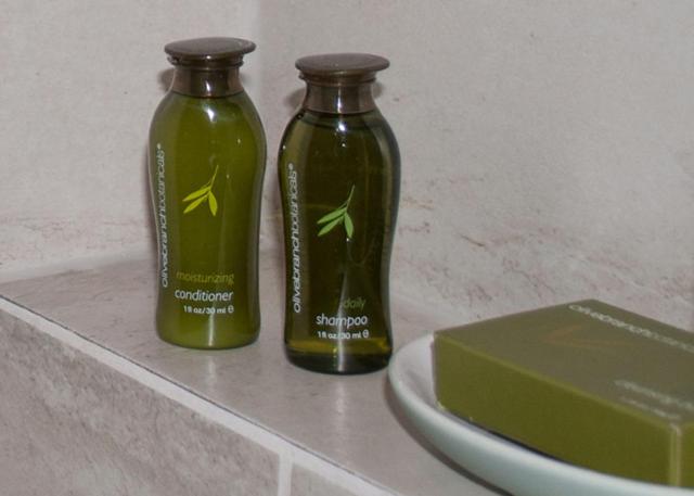 two green bottles sitting on a counter next to a plate at Harbour House Hotel in Ganges