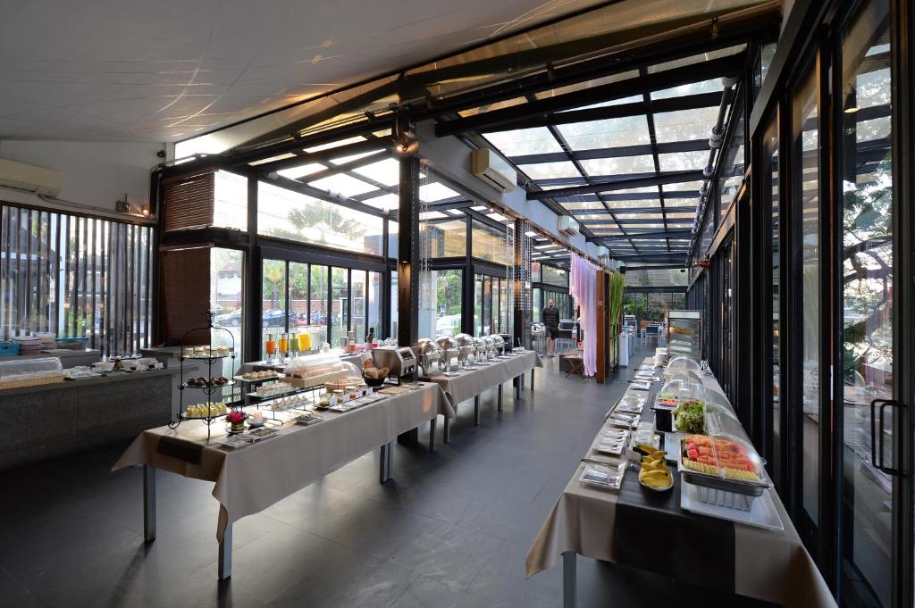 A glass-walled breakfast area is set up with long buffet tables.