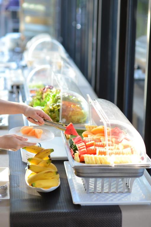 A bright buffet station serving cut fruit and salad.