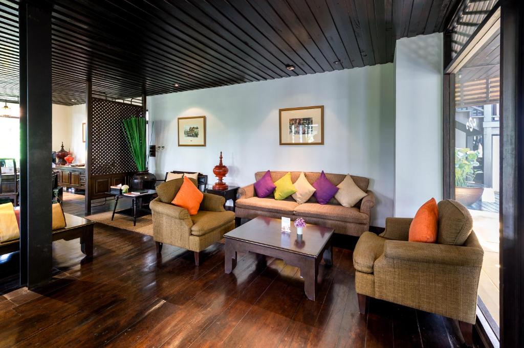 A warmly furnished lounge with sofas, armchairs and a coffee table.
