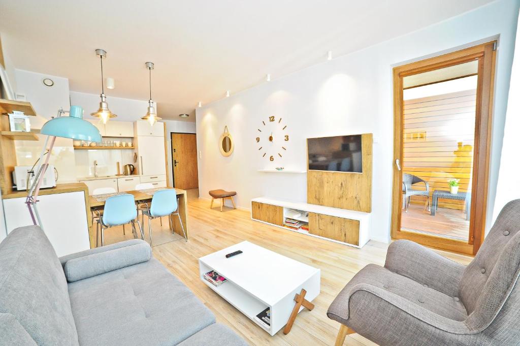 a living room with a couch and a table at Bursztynowa Apartments by Grand Apartments in Gdańsk