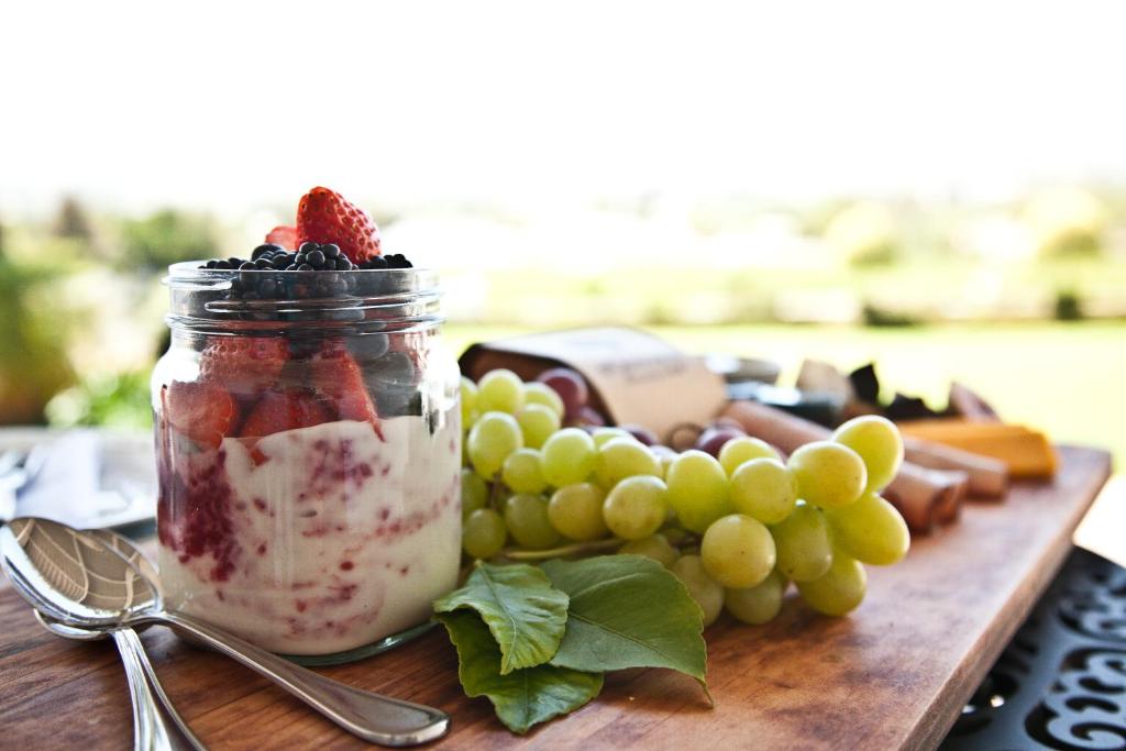 a jar of fruit with grapes and a strawberry in it at d'Olyfboom Guest House B & B in Paarl