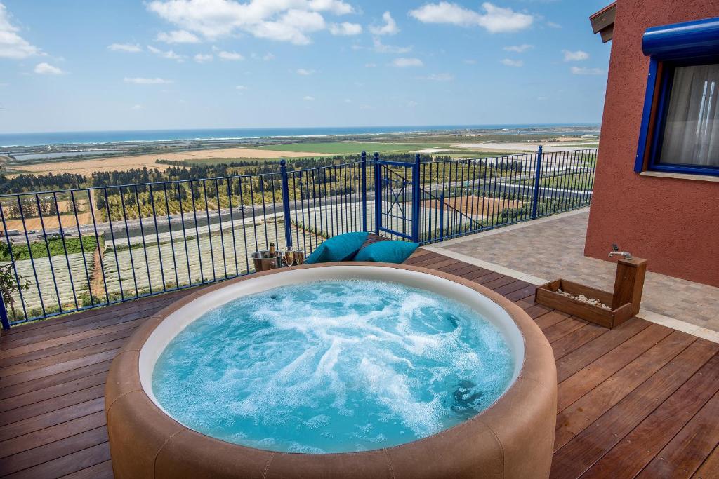 bañera de hidromasaje en la cubierta de una casa en Yama Wine Spa and Suites, en Zikhron Ya‘aqov