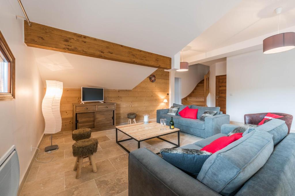 a living room with two blue couches and a table at Les Terrasses De Perrières in Les Gets