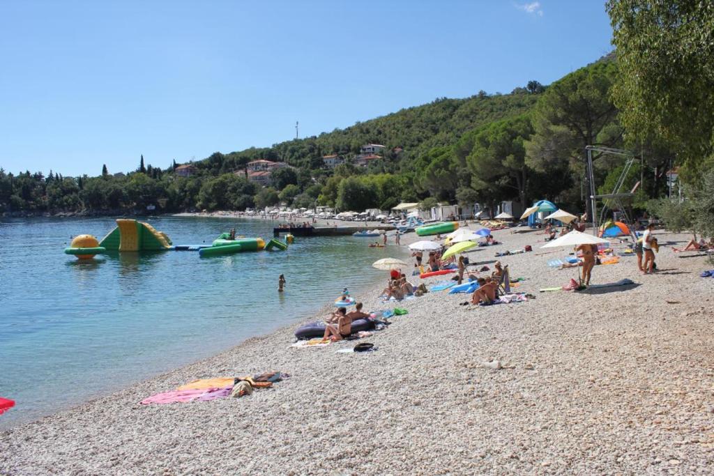 a group of people on a beach near the water at Apatmani Milena in Opatija