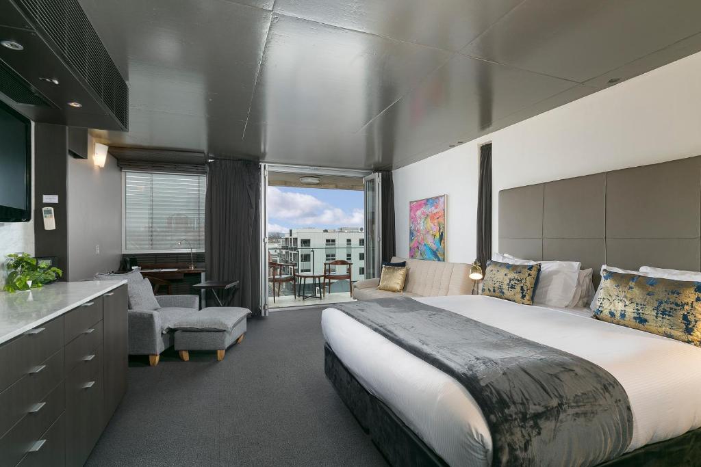 a large bedroom with a large bed and a kitchen at The Soho Hotel in Adelaide