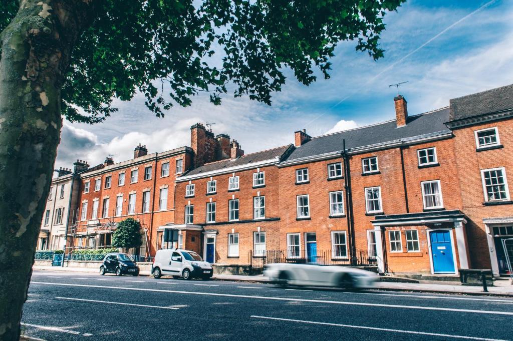 een auto die door een straat rijdt voor gebouwen bij The Stay Company, Friar Gate in Derby