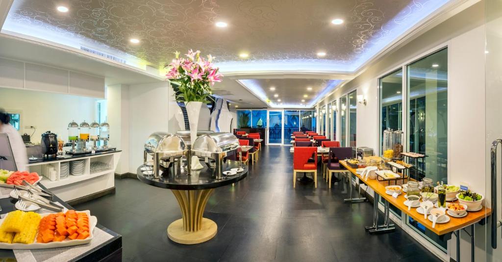 A long, bright breakfast room with buffet stations along both sides.
