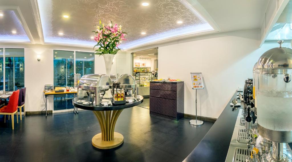 A spacious breakfast room contains a central buffet island and a long beverage counter.